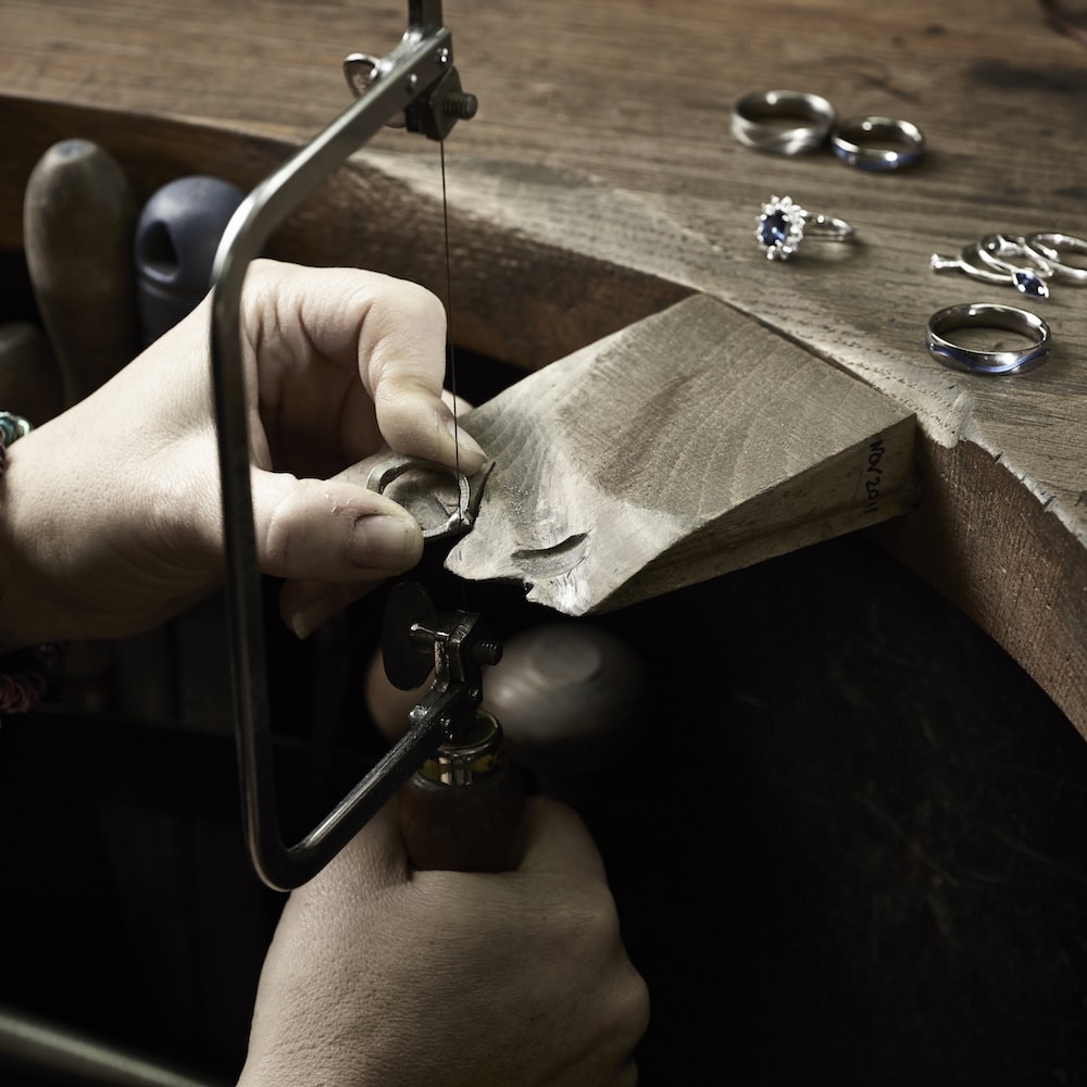 titanium ring finishing with saw on wooden bench