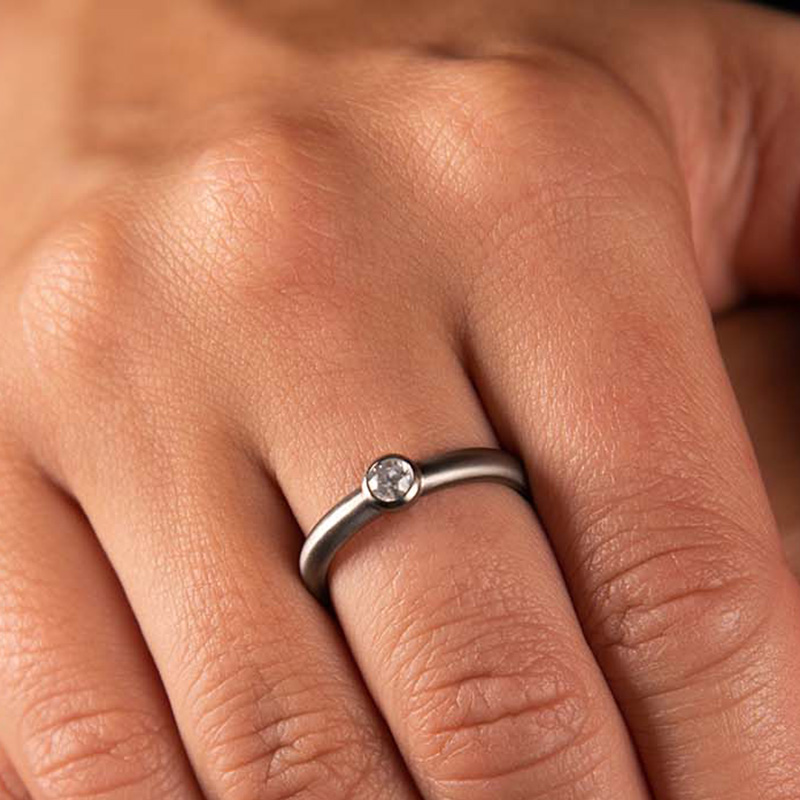 Stone set titanium with diamonds.